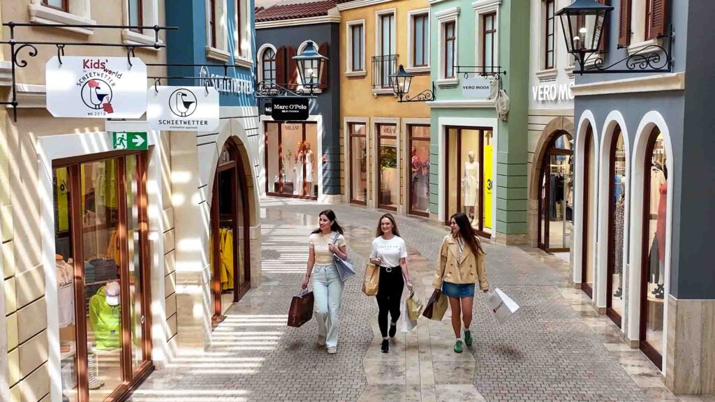 Frauen mit Einkaufstaschen die entspannt durch die Mall schlendern